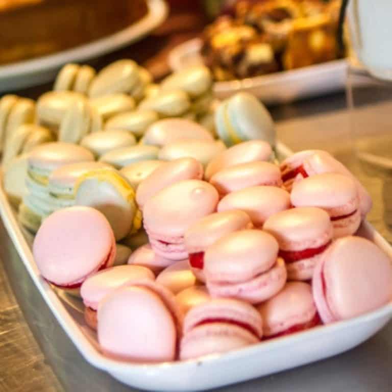 A rectangular plate with pink and green macarons.