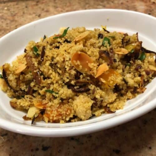 An oval white bowl filled with spiced Couscous recipe