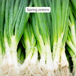 an image of bundles of spring onions stacked ready for purchase.