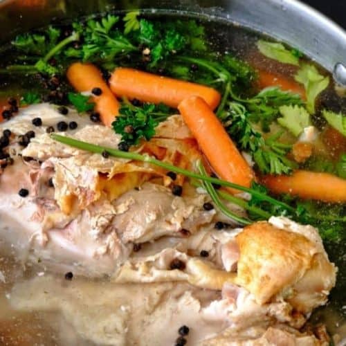 Close up of chicken and veg in a pot making chicken stock