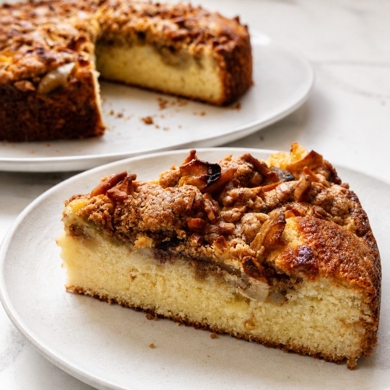 A slice of Pear and Almond Crumble Cake on a white plate.
