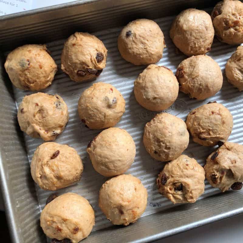 A baking tray with balled up hot cross bun dough, just before the proving stage.