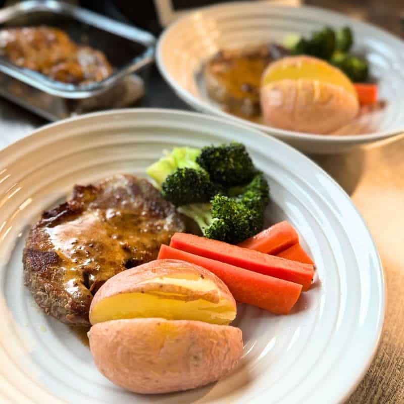 Two plates with our creamy mustard pork, carrot, broccoli and potato.