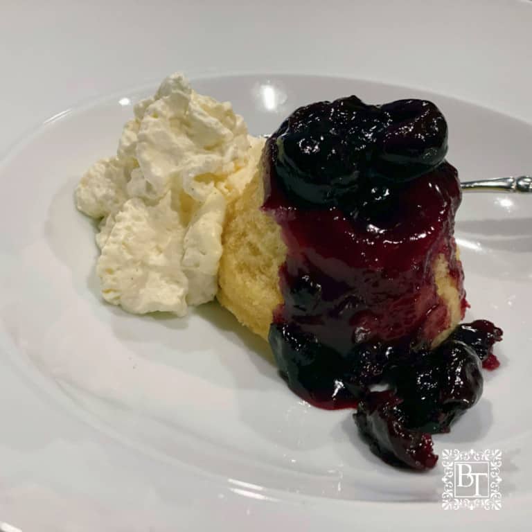 Vanilla and cherry steamed pudding with whipped cream.