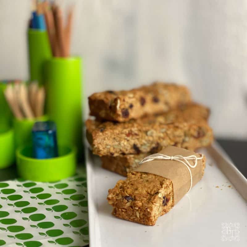 Muesli slices next to some pencils in a green stationary organiser.