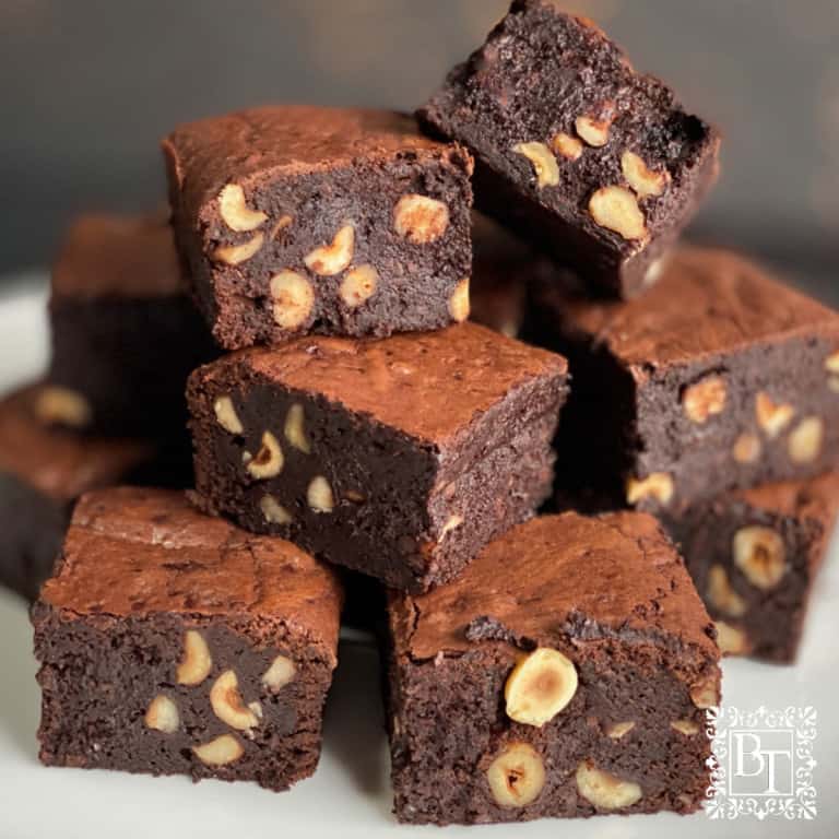 White plate with a stack of beetroot and hazelnut brownie cubes